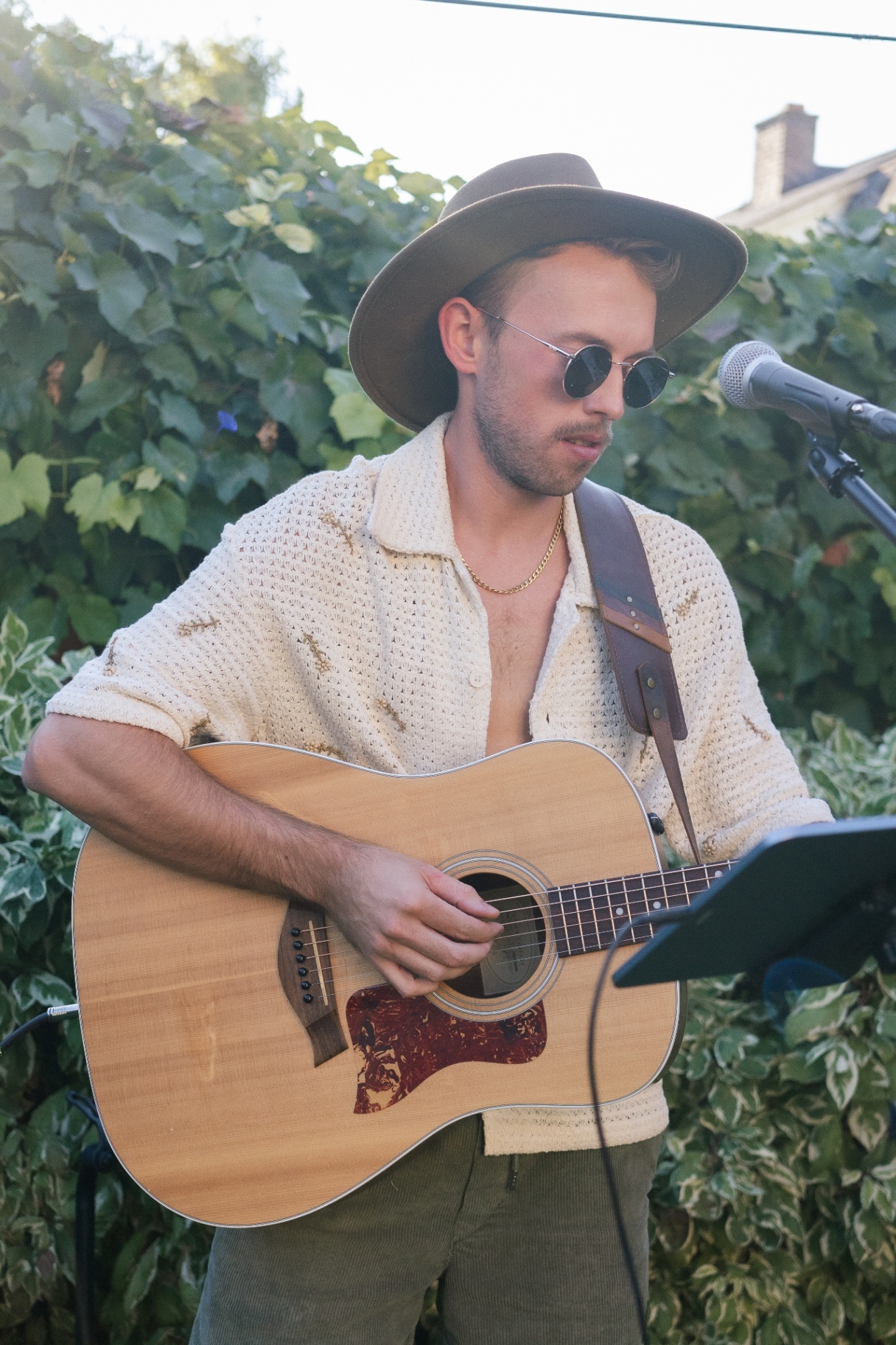 Vocalist in wide-brim hat with acoustic guitar